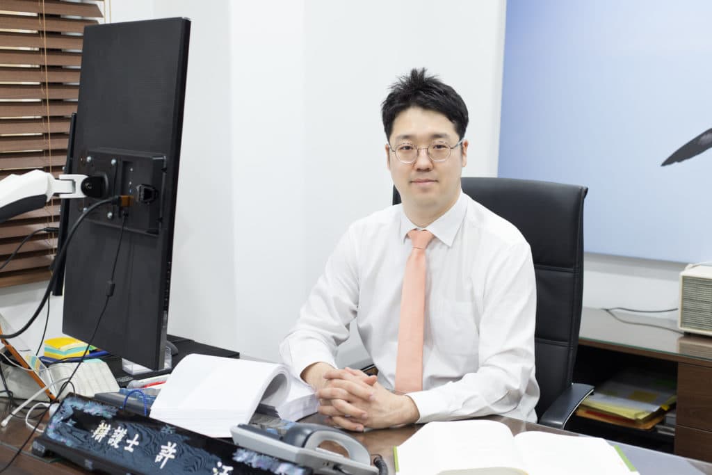 Attorney Wang Huh reviewing documents at his office